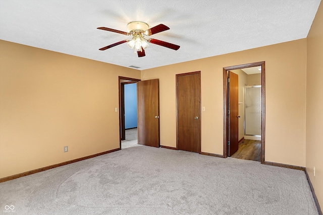 unfurnished bedroom with visible vents, baseboards, a textured ceiling, and ensuite bath