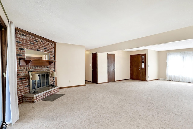 unfurnished living room with a brick fireplace, baseboards, and carpet floors