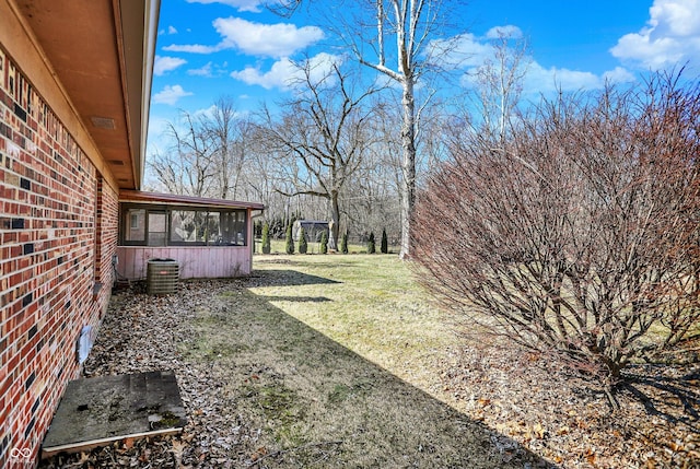 view of yard featuring central AC unit and a sunroom