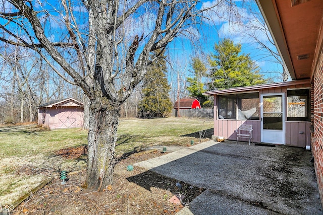 view of yard with a storage shed, an outdoor structure, a patio area, and a sunroom