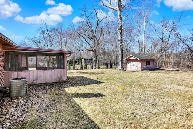 view of yard with an outdoor structure, central air condition unit, a shed, and a sunroom