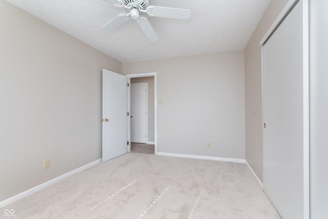 unfurnished bedroom with a closet, baseboards, carpet floors, and ceiling fan