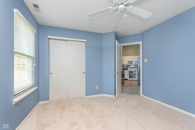 unfurnished bedroom with visible vents, a closet, carpet, baseboards, and ceiling fan