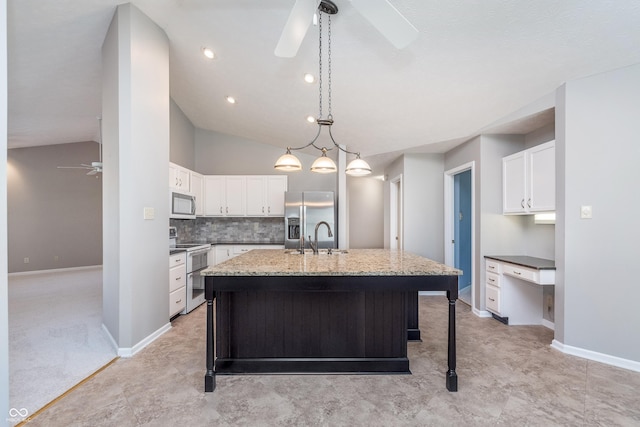 kitchen with backsplash, vaulted ceiling, appliances with stainless steel finishes, white cabinetry, and a ceiling fan