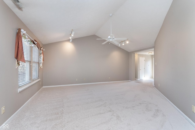 spare room featuring baseboards, light carpet, a ceiling fan, and vaulted ceiling