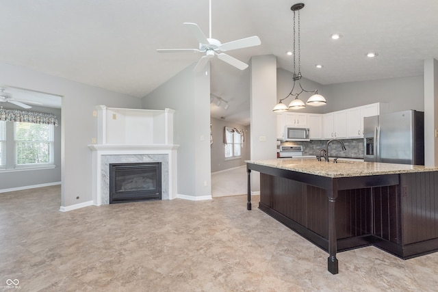 kitchen featuring range with electric stovetop, white cabinetry, stainless steel fridge, light stone countertops, and ceiling fan