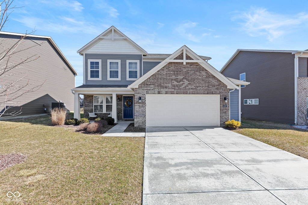 view of front of home with a front yard, an attached garage, brick siding, and driveway