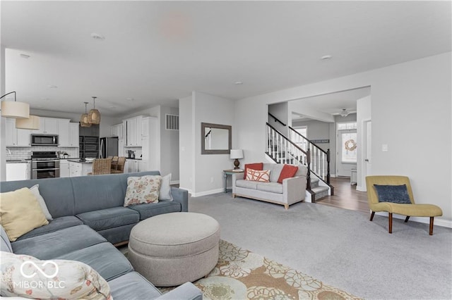 living area featuring stairway, baseboards, carpet, and visible vents