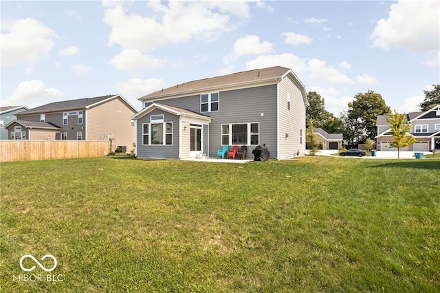 rear view of property with a patio, fence, and a lawn