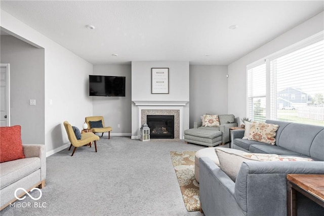 living room featuring a glass covered fireplace, carpet, and baseboards