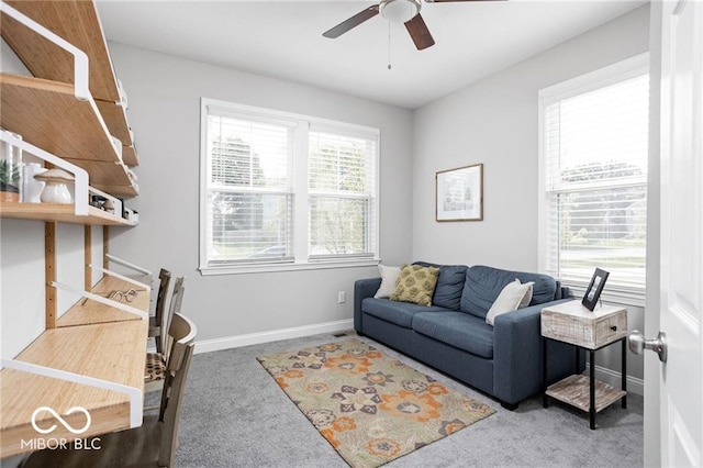 living area with baseboards, carpet floors, and a ceiling fan