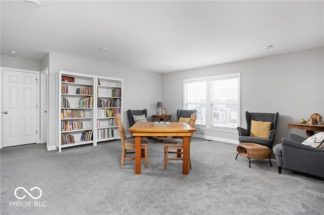 carpeted dining area with baseboards