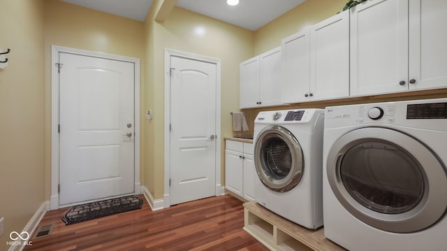 laundry room featuring visible vents, cabinet space, washing machine and dryer, and dark wood finished floors