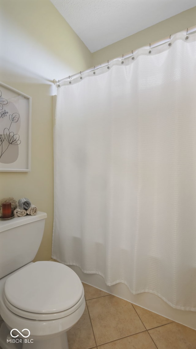 bathroom featuring tile patterned floors, toilet, and shower / bath combo