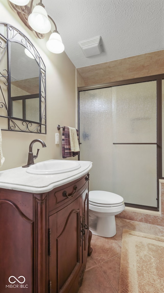 full bath featuring tile patterned floors, visible vents, a textured ceiling, a shower stall, and vanity