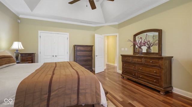 bedroom with ceiling fan, baseboards, lofted ceiling, wood finished floors, and a closet