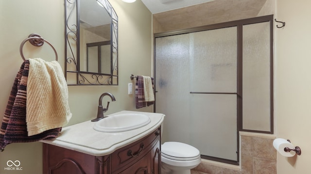 bathroom featuring tile patterned flooring, toilet, a stall shower, and vanity