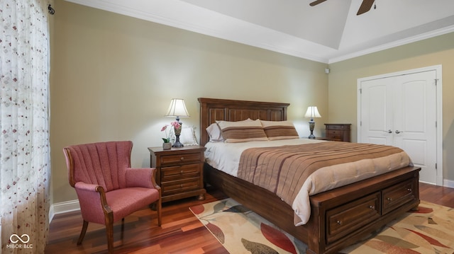 bedroom featuring vaulted ceiling, crown molding, baseboards, and wood finished floors