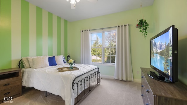 carpeted bedroom with baseboards, a ceiling fan, an accent wall, and wallpapered walls