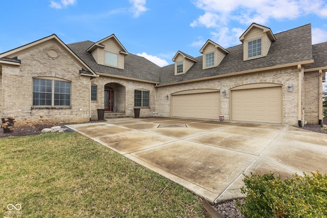 view of front of property featuring driveway, brick siding, and roof with shingles