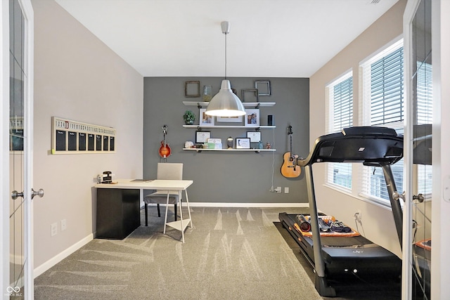 workout area featuring carpet and baseboards