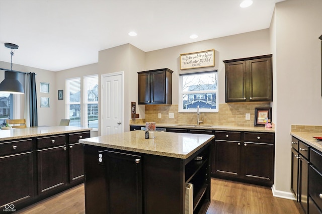 kitchen with a sink, light wood-style floors, a wealth of natural light, and a center island