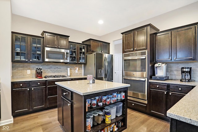 kitchen with dark brown cabinets, light wood-style flooring, appliances with stainless steel finishes, and open shelves