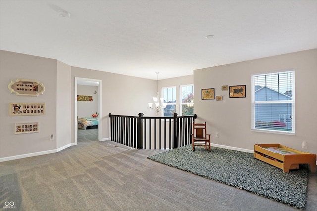 sitting room featuring baseboards, carpet floors, and a notable chandelier