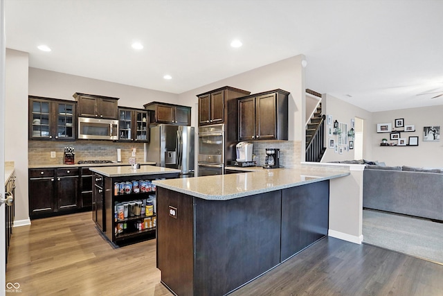 kitchen featuring dark brown cabinets, appliances with stainless steel finishes, and wood finished floors