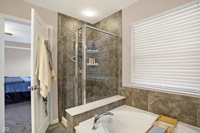 ensuite bathroom with a textured ceiling, ensuite bath, a stall shower, and a bath