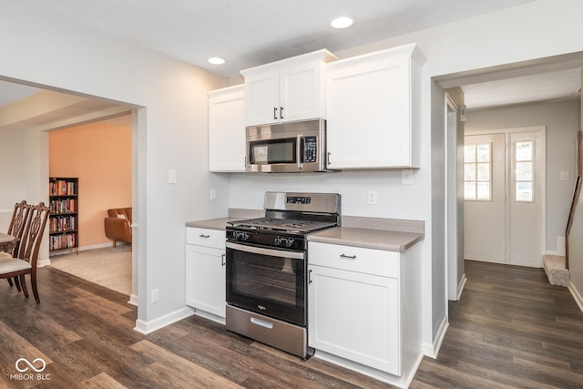 kitchen with dark wood finished floors, recessed lighting, stainless steel appliances, white cabinets, and baseboards