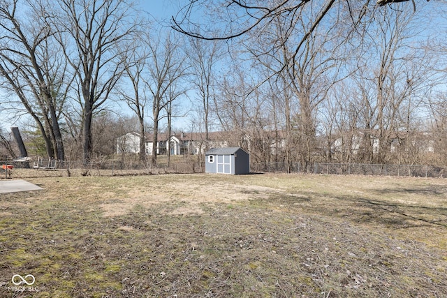 view of yard with an outbuilding, a storage shed, and fence