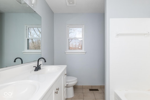 bathroom featuring toilet, plenty of natural light, and a sink