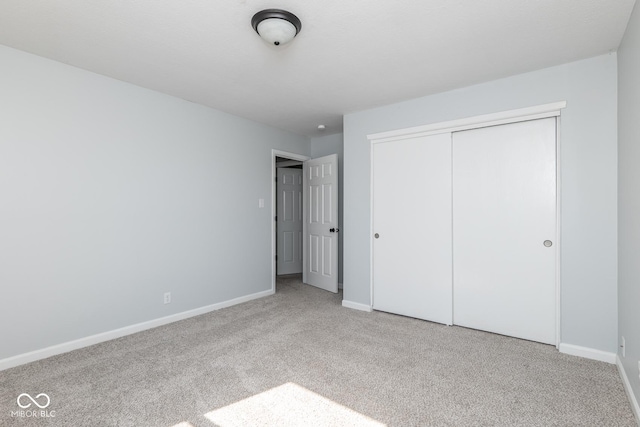 unfurnished bedroom with carpet, baseboards, and a closet