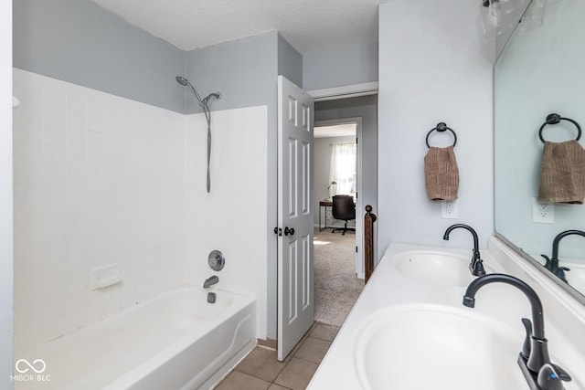 full bath featuring tile patterned flooring, a textured ceiling, bathtub / shower combination, and a sink