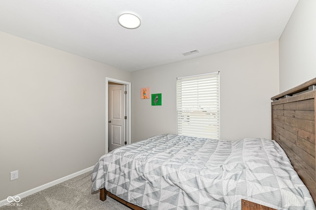 carpeted bedroom featuring visible vents and baseboards