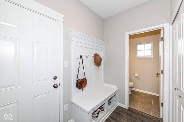 mudroom with dark wood-style floors and baseboards