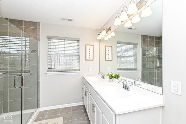 bathroom with tile patterned floors, a shower stall, baseboards, and a sink