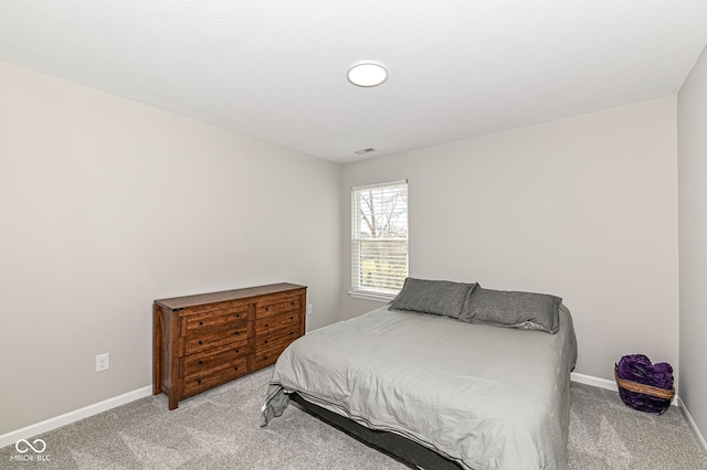 bedroom featuring visible vents, light colored carpet, and baseboards