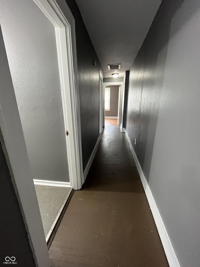 hallway featuring visible vents and baseboards