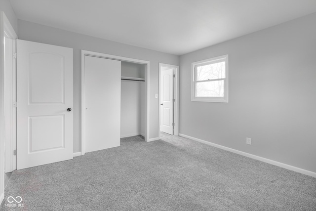 unfurnished bedroom with a closet, baseboards, and carpet