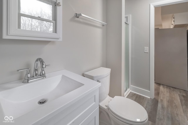 full bath featuring wood finished floors, toilet, a stall shower, and vanity