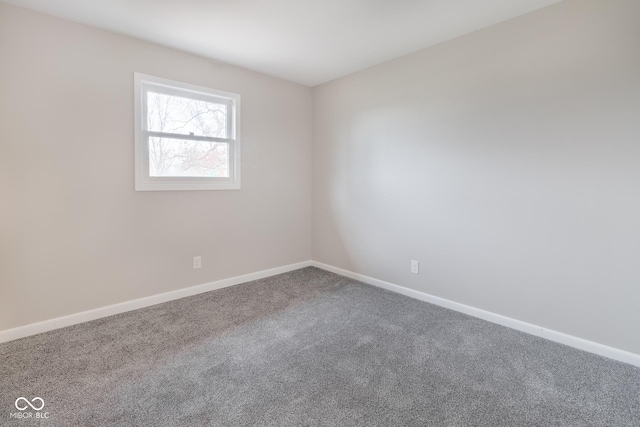 spare room featuring baseboards and carpet floors