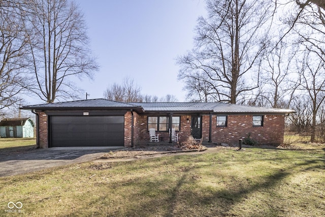 view of front facade with a front lawn, driveway, an attached garage, metal roof, and brick siding