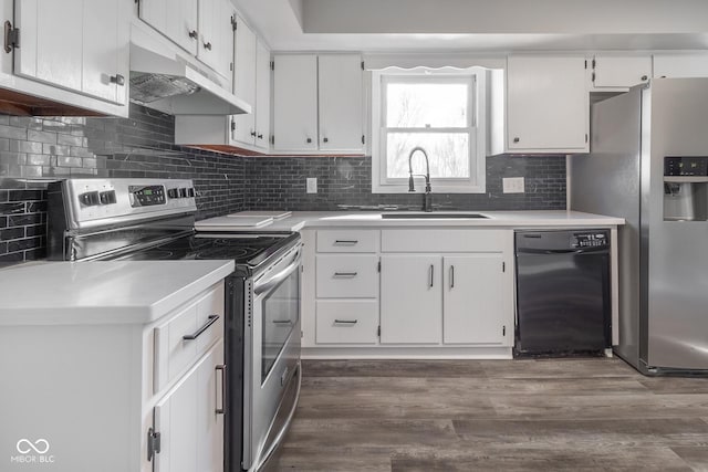 kitchen with a sink, under cabinet range hood, tasteful backsplash, dark wood finished floors, and appliances with stainless steel finishes