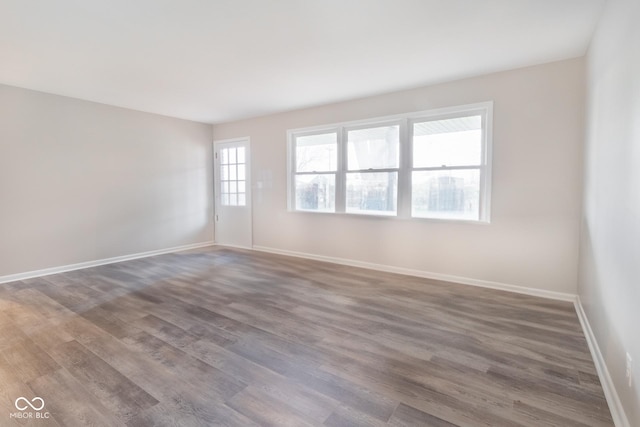 empty room featuring baseboards and wood finished floors