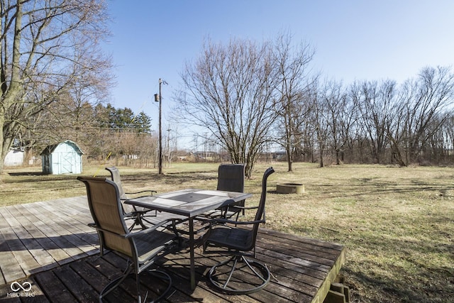 wooden terrace with an outbuilding, a storage shed, and outdoor dining area