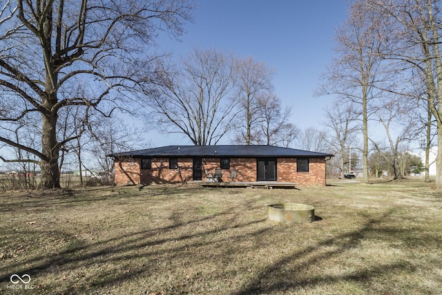 view of front of home with brick siding, metal roof, and a front yard