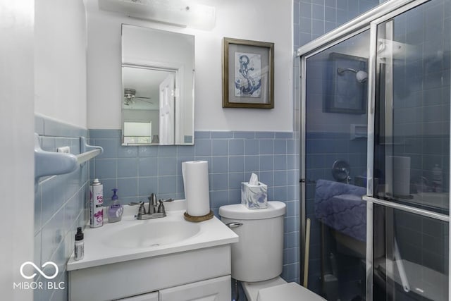 6204 S Madison Ave, Indianapolis, IN 46227 - full bathroom featuring vanity, a shower stall, ceiling fan, tile walls, and a wainscoted wall