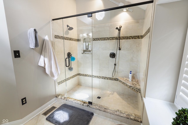 bathroom with a shower stall and baseboards